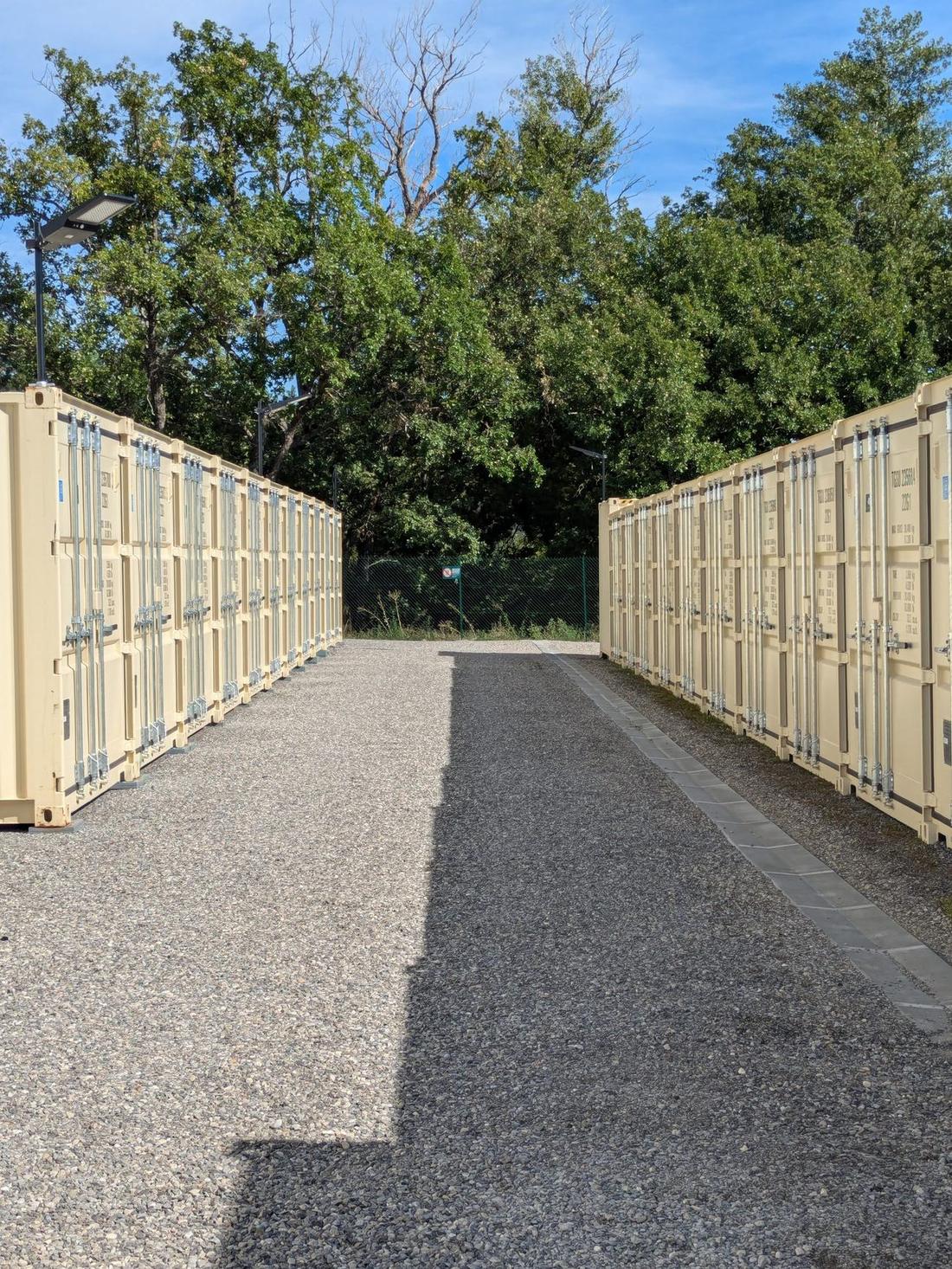 Allée de gravier entre deux rangées de box de stockage