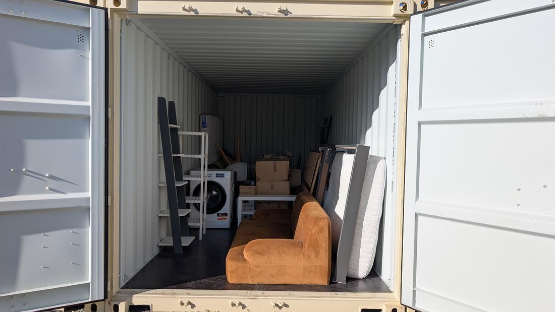 Portes ouvertes sur un box chargé de mobilier et d’électroménager