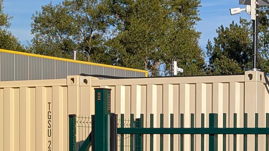 Conteneurs beiges et clôture à l’entrée du site des Box Martin